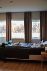 Seng ved tre vinduer med høstutsikt i Suite 3