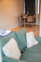 Grønn sofa og rundt spisebord i Suite 3