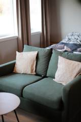Grønn sofa med puter i Suite 3